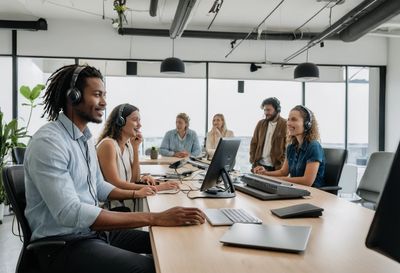 People in a bright open office each on their own headset call